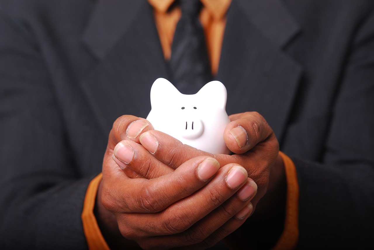 Cofrinho de porquinho branco com moedas — Saque-Aniversário do FGTS para nascidos em agosto de 2026